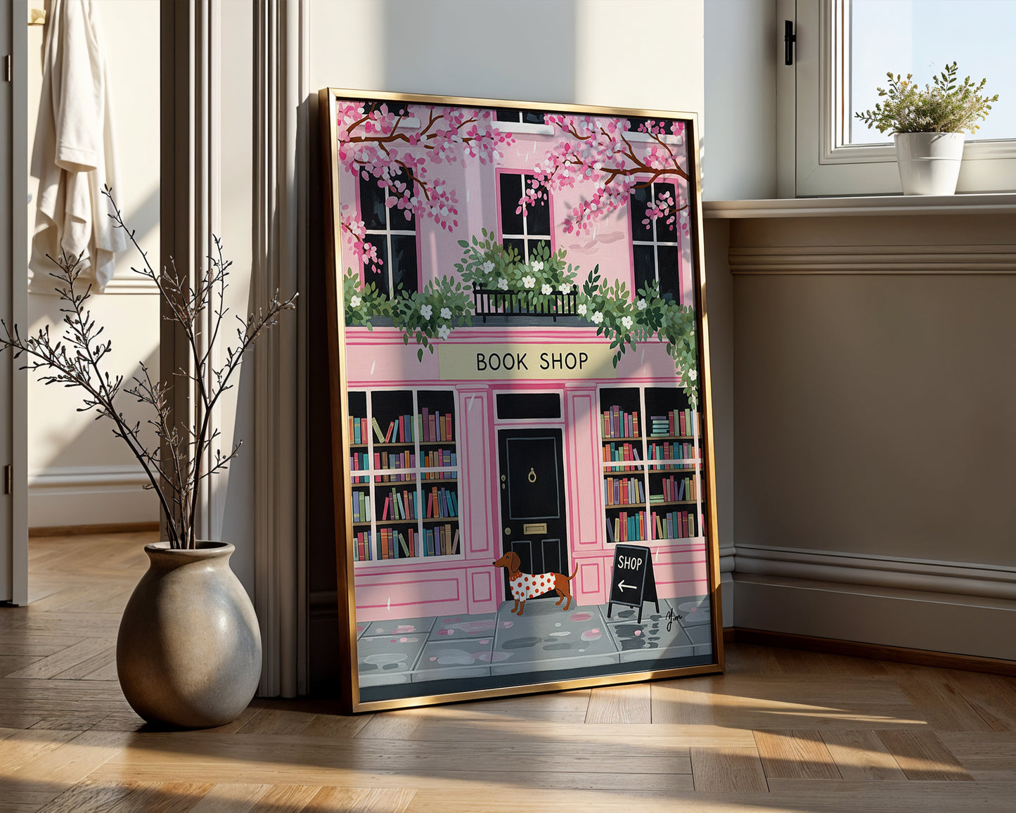 Dachshund in red polka dot sweater standing in front of pink bookshop with cherry blossoms and books