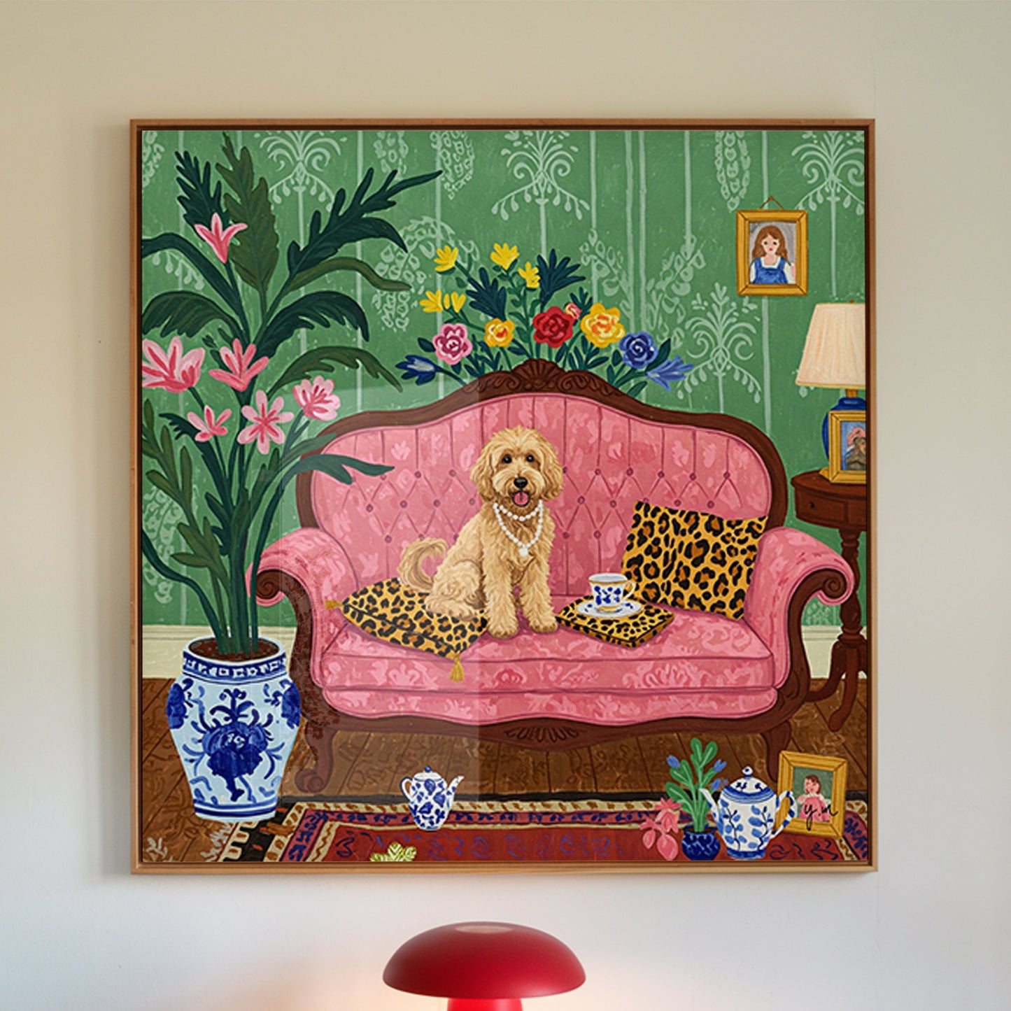 Whimsical illustration of a fluffy dog wearing pearl necklaces, sitting on a pink vintage sofa with leopard print cushions. The green wallpaper background, floral arrangements, and blue porcelain tea set create an elegant, cozy setting. This playful artwork is ideal for pet lovers and fans of vintage interior design.