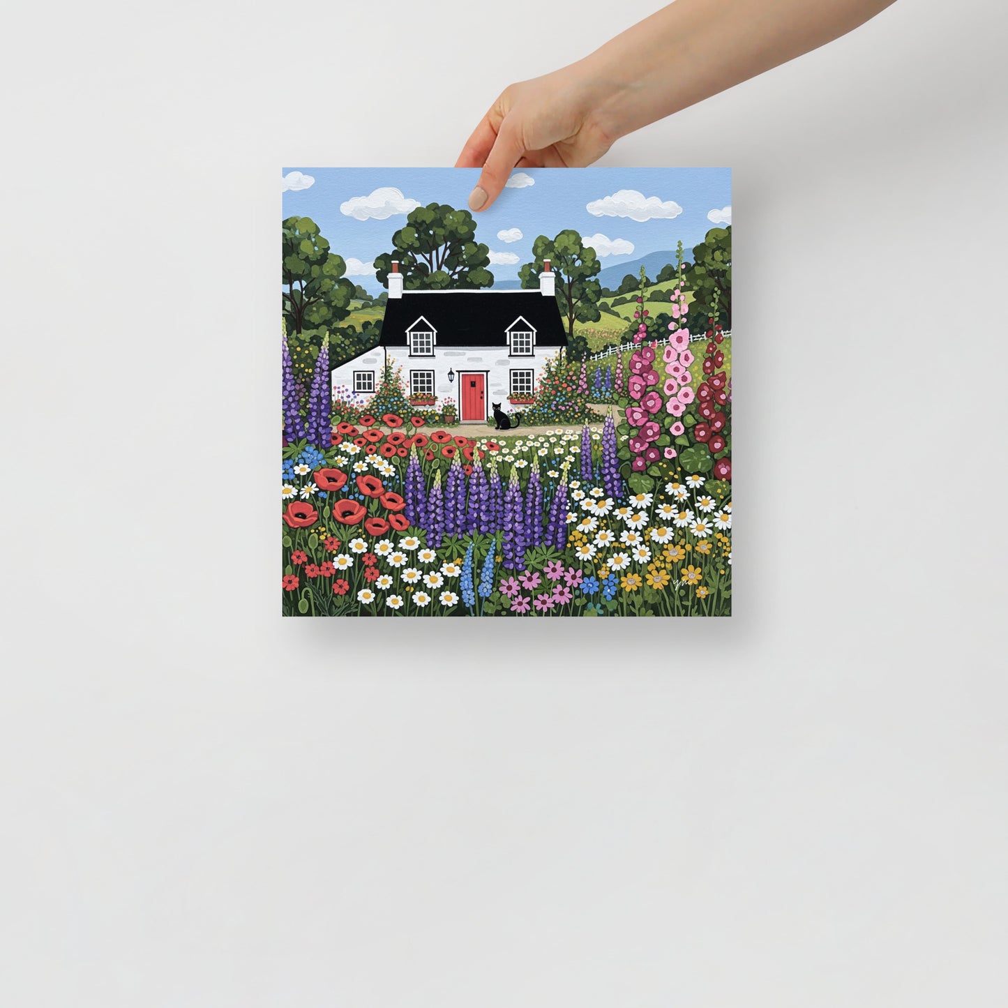 Cozy white cottage with red door, colorful wildflowers, and black cat illustration for floral wall decor.