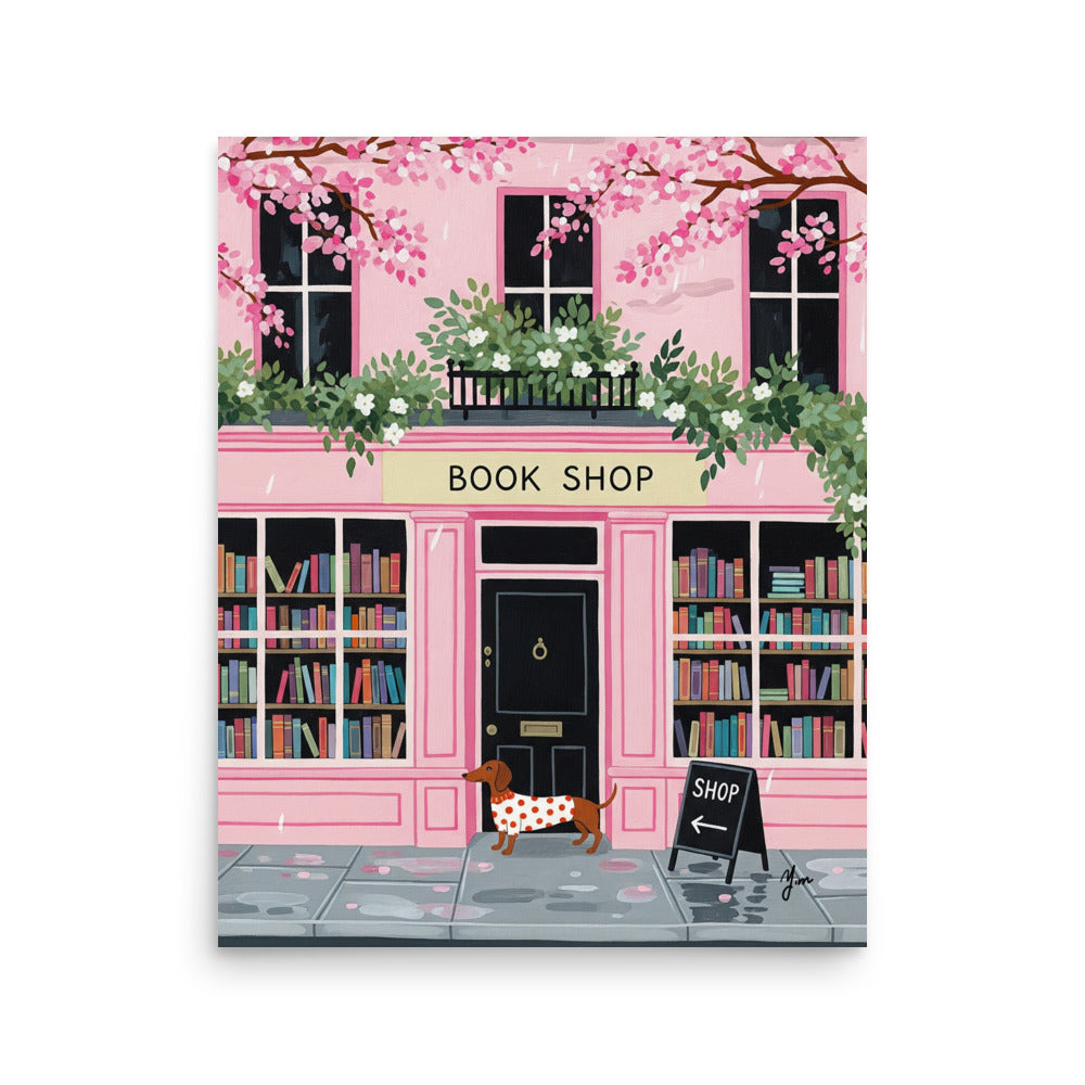 Dachshund in red polka dot sweater standing in front of pink bookshop with cherry blossoms and books
